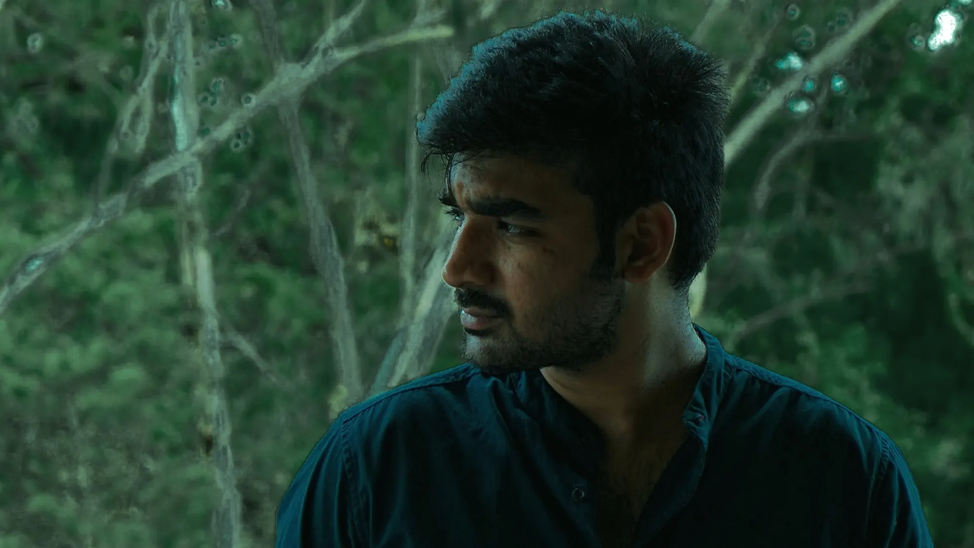 Portrait of Priyatham Rathod, looking to the side, in front of trees